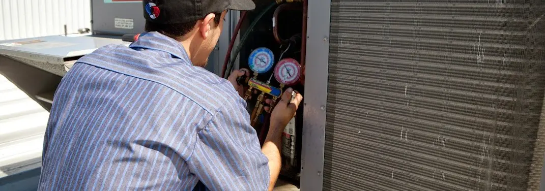 HVAC technician servicing a condenser unit in Eureka