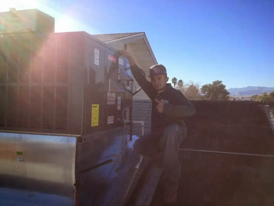 HVAC technician performing AC Tune-Up on a rooftop unit in Eureka